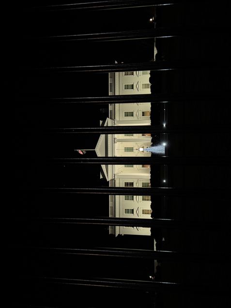The White House at night viewed through a gate