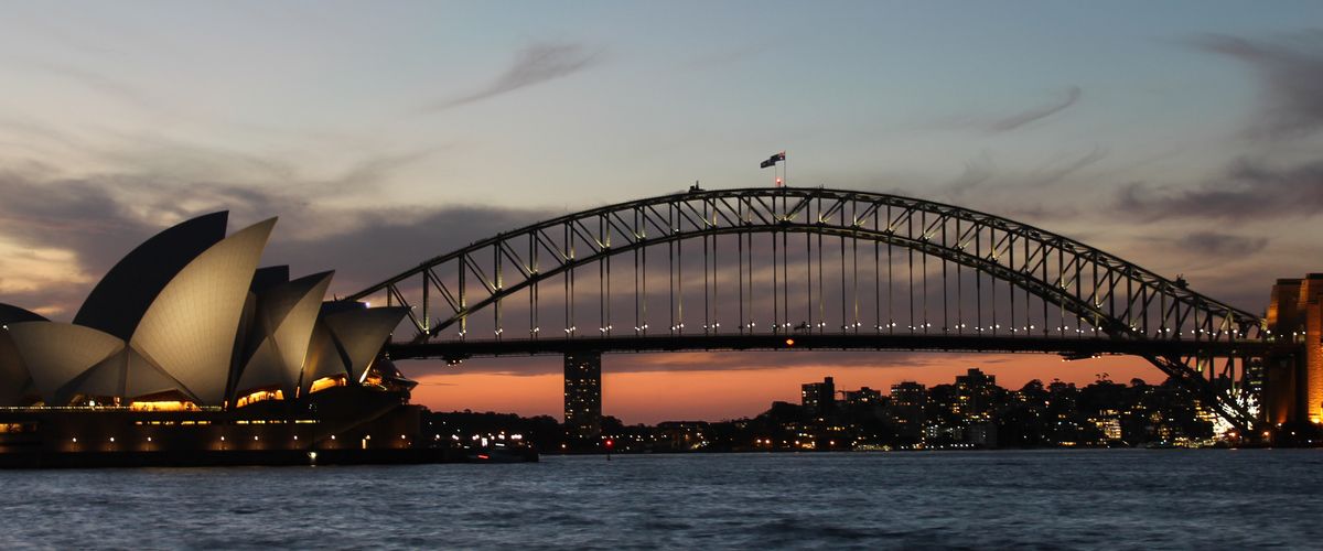 view of sydney harbor bridge and opera house at dusk