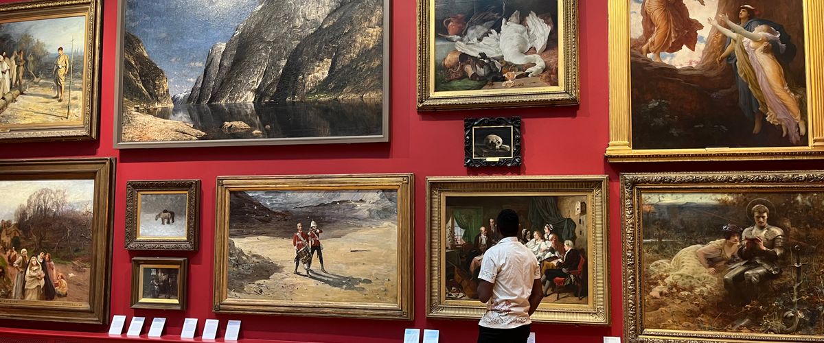 MAn looking at painting in a museum gallery