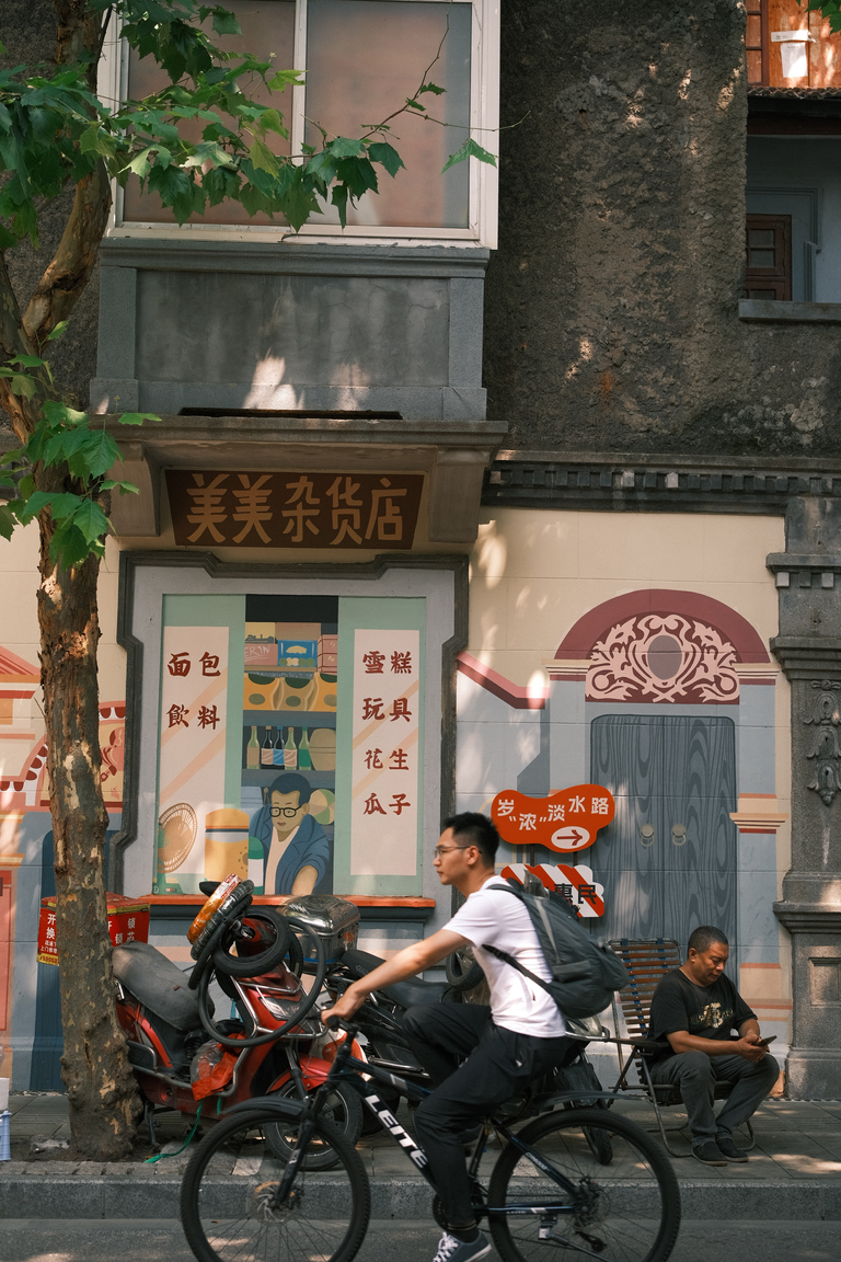 Man on bike riding throuygh french concession in Shanghai
