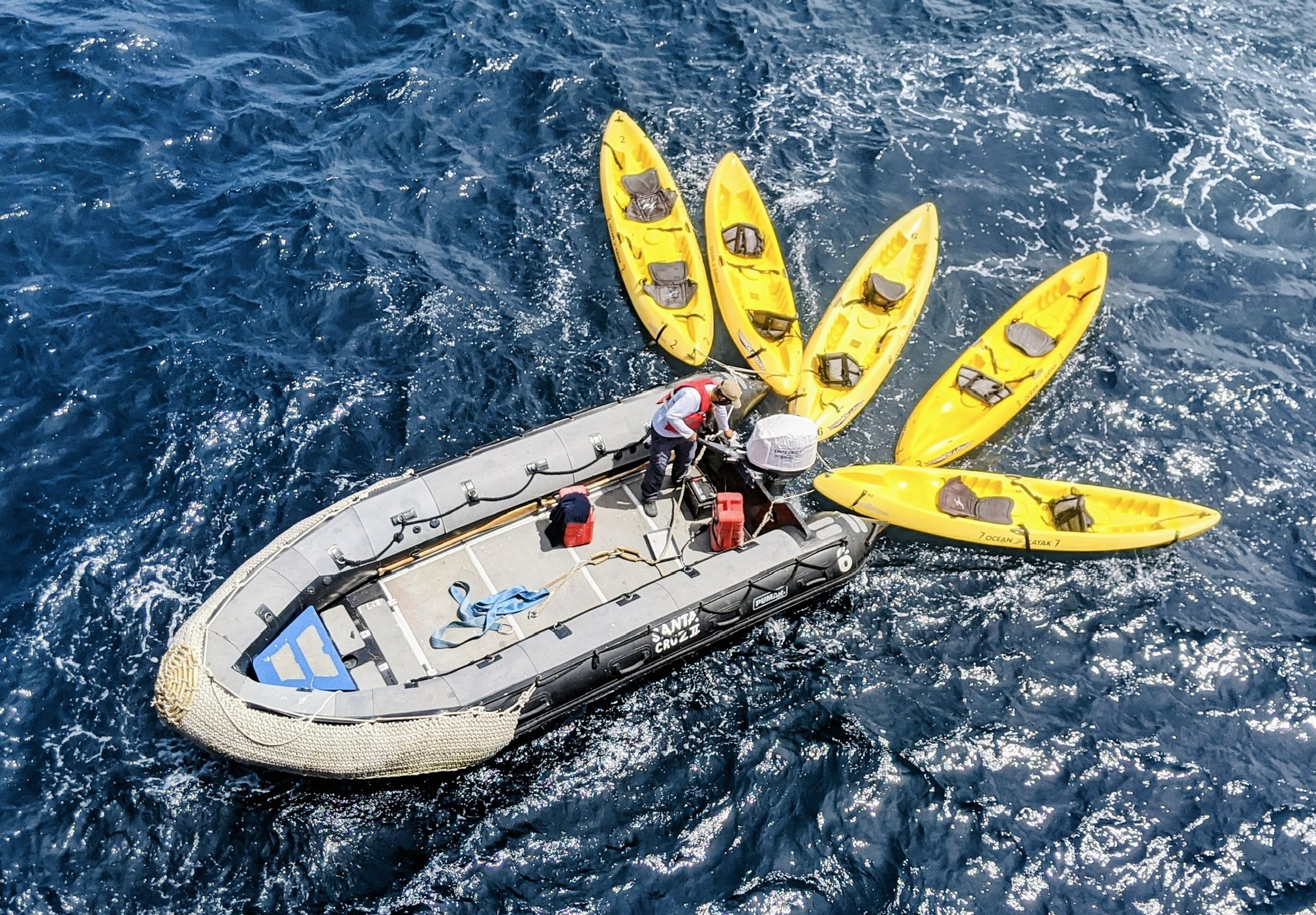 zodiac with yellow kayaks tied up to it