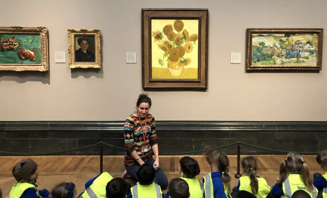 docent in museum telling school children about paintings