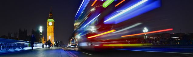 Night image of Big ben with bus moving past