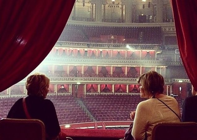 two women sitting in a bacony of an empty theater