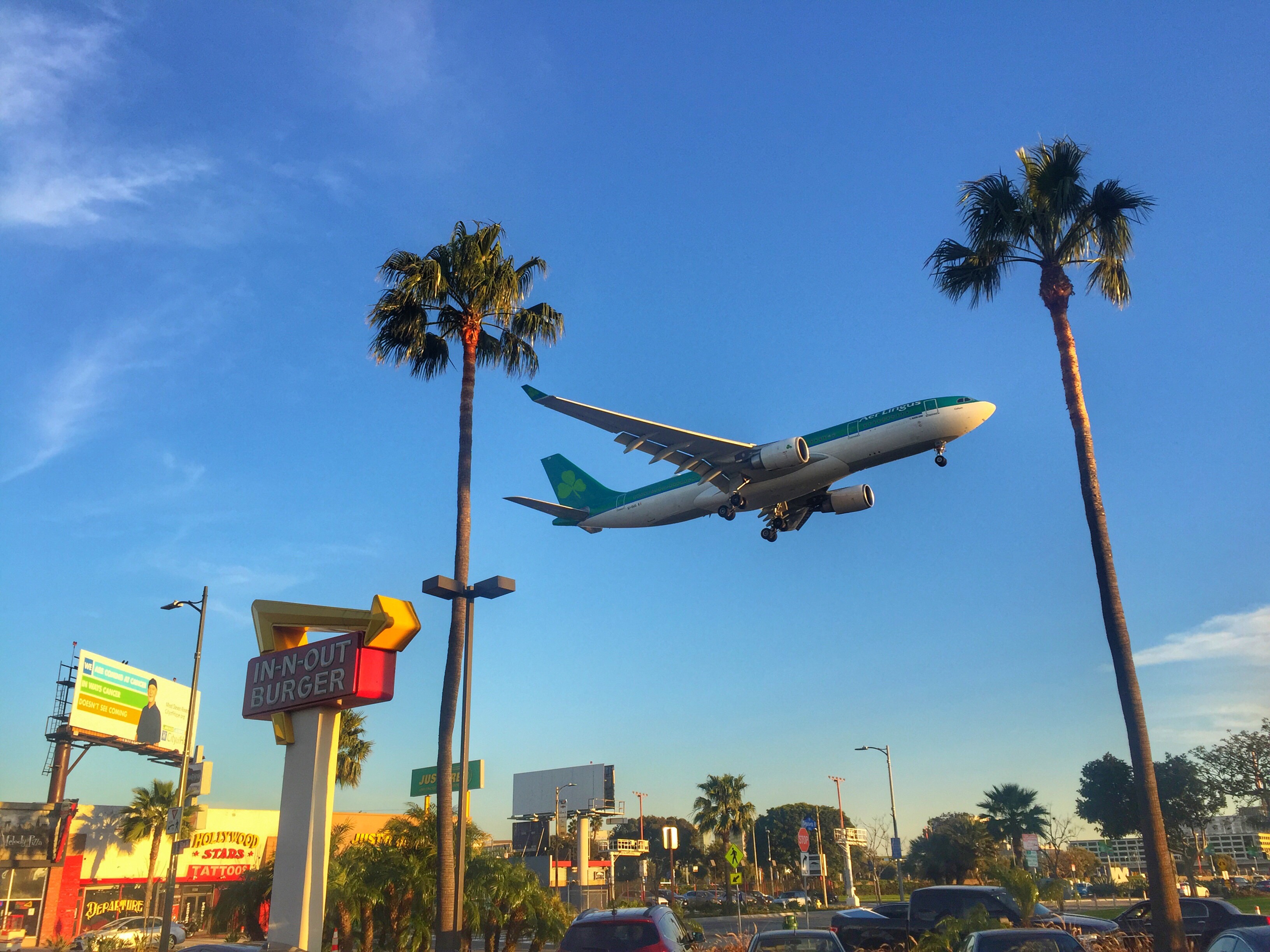 Air Lingus plan flying low over In and out burger sign in LA CA
