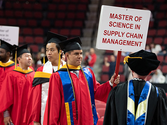 Graduates in Supply Chain Management program getting ready to walk at commencement.