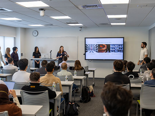 BU alum Laura McIntosh delivers a presentation in a classroom full of students