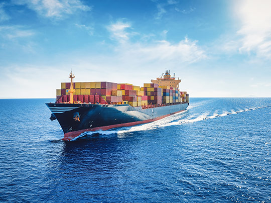 A cargo ship carrying shipping containers across a body of water