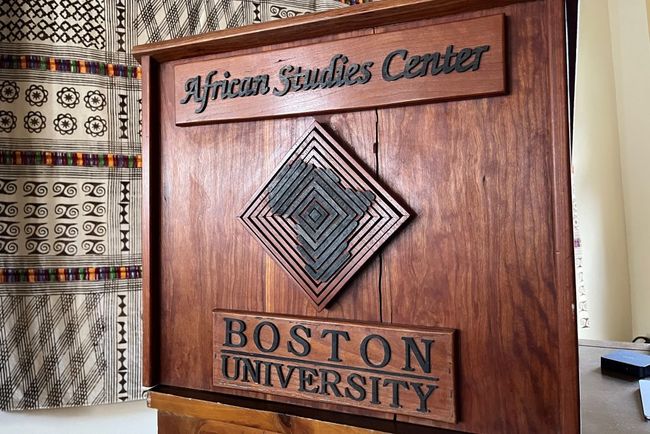 A picture of the wooden podium of the African Studies Center in its main seminar room, with an engraving of the African continent