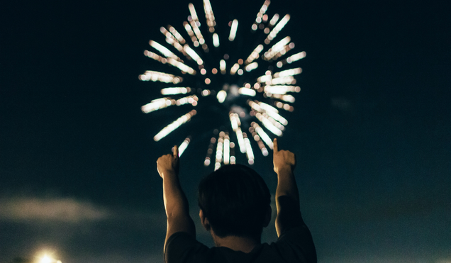 Man in black shirt pointing at fireworks