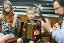 Irish musicians play music and poet reads poetry during and interdisciplinary class on the literature, politics, and culture of Irish Bostonians in the 19th and 20th century in the CGS building