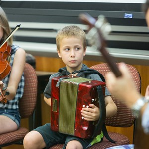 Irish musicians play music and poet reads poetry during and interdisciplinary class on the literature, politics, and culture of Irish Bostonians in the 19th and 20th century in the CGS building