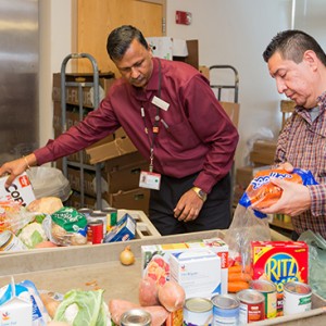 Latchman Hiralall, manager of Boston Medical Center’s Preventive Food Pantry (left), and food pantry assistant Juan Carlos Turcios prepare a cart of food for a patient. Photos by Dana J. Quigley