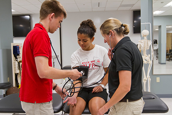 BU athletic training students Cyprien Jungels, red shirt, Amanda Fraden, white shirt and staff Erica Shaya, black shirt.
