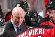 Head Coach of the New Jersey Devils John Hynes talks to his players on the bench during a timeout