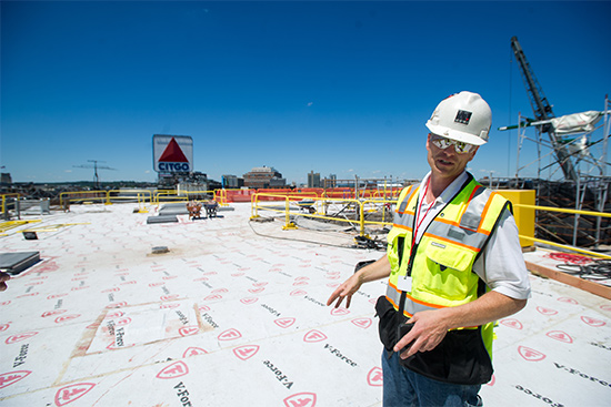 Al Hartshorn, Shawmut Design and Construction senior project superintendent, stands on Myles Standish Hall's new roof