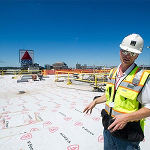 Al Hartshorn, Shawmut Design and Construction senior project superintendent, stands on Myles Standish Hall's new roof