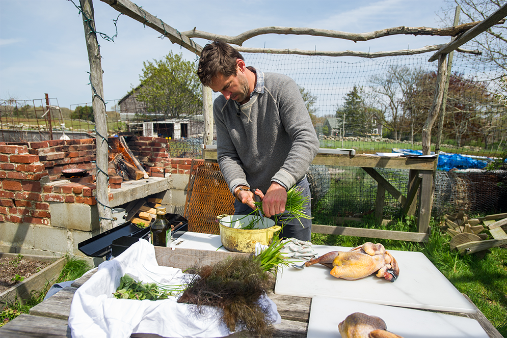 Chef Chris Fischer prepares greens for dinner at Beetlebung Farm in Chilmark, Massachusetts on Marth's Vineyard