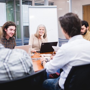 Cathie Jo Martin and intern Ben Getchell sitting in a room at a meeting
