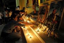 Cubans mourning light up candles in front of photos of Castro