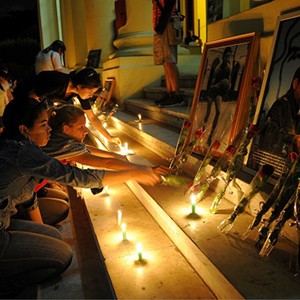 Cubans mourning light up candles in front of photos of Castro