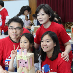 Young-chun Cho (clockwise from top left) his wife, Soojeong Kim, and their daughter Hyunjoo Cho work with an orphan from Dream Tree Village at a Global Days of Service event last year.