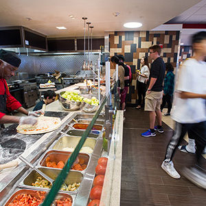 Fresh Food Co cook Jean St. Joy makes pizzas int he Warren Towers dining hall.