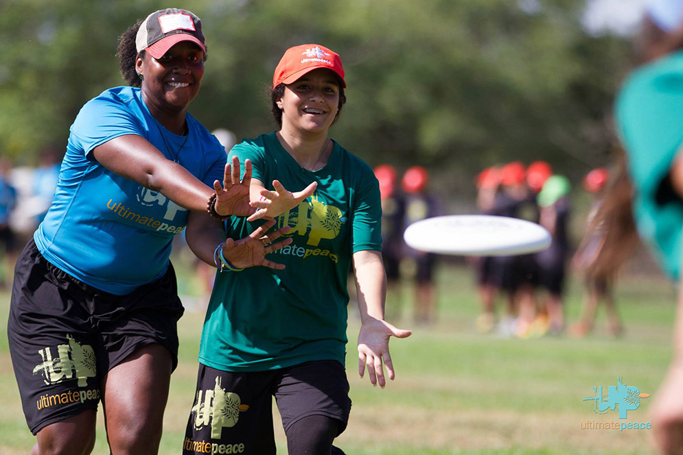 Dana Dunwoody with youth reaching for mid-air disc