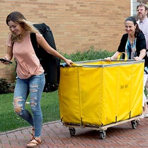 Student pushing move-in cart with her parents
