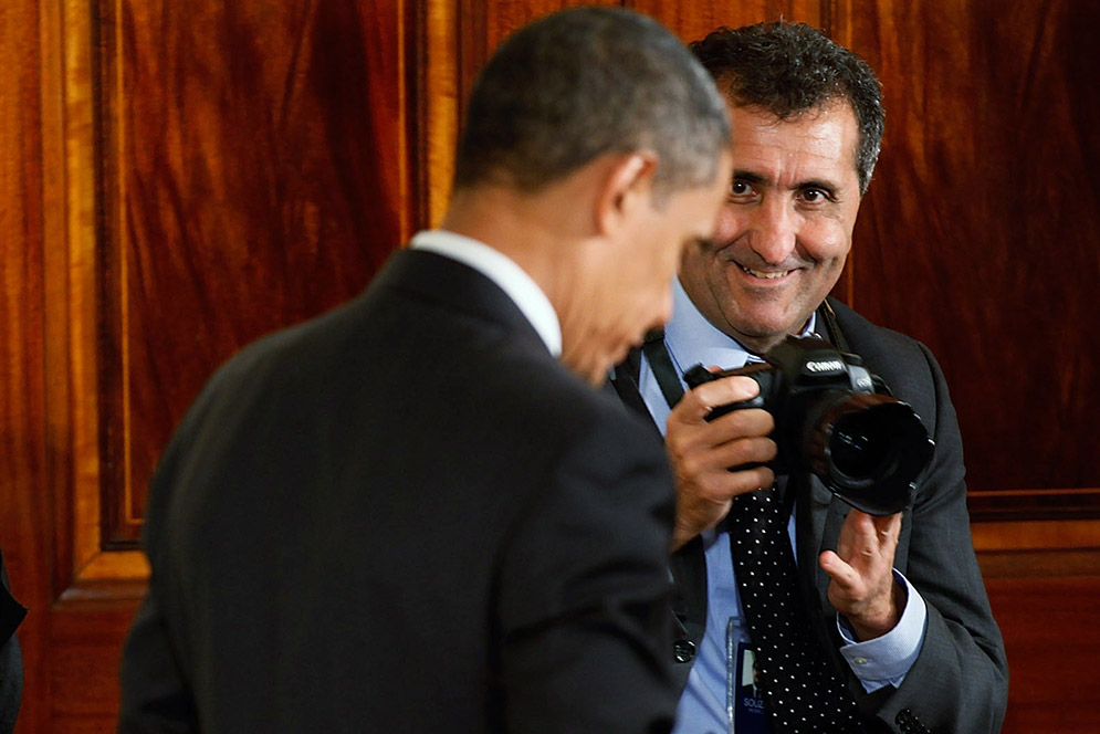 White House photographer Pete Souza, camera ready, with President Obama during an event celebrating the Affordable Care Act in 2010