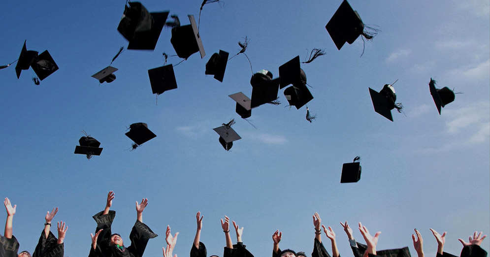 graduation caps in the air