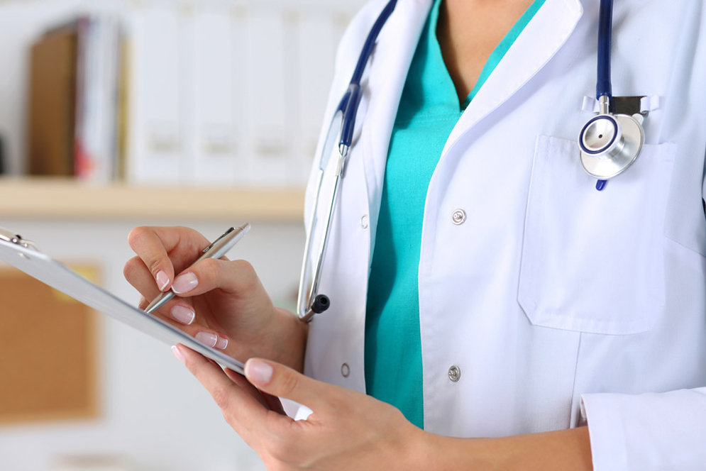 A medical student writes using a clip board