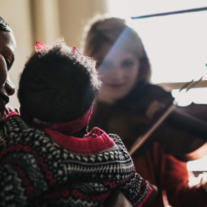 Congolese immigrant Shana (left) worked with CFA alums in the chamber group Palaver Strings—led by violinist Maya French (CFA’15,’18) (right)—to write a lullaby for her baby girl.