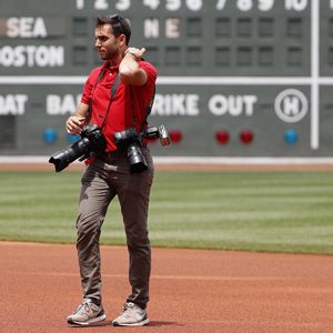 Billie Weiss, the Red Sox manager of photography, on the field wearing multiple cameras