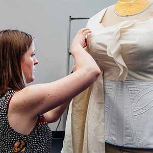 A theatre student working in the Boston University College of Fine Arts costume shop works tailoring a women's costume for the stage production of Angels in America.