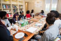 Shadae Leslie (COM'20) at left, and Nneka Oyigbo (CAS'20) listen to faculty member Sucharita Gupal