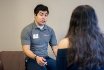 Augustine Jimenez being interviewed while wearing his Residence Life shirt