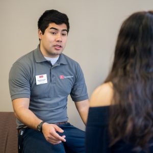 Augustine Jimenez being interviewed while wearing his Residence Life shirt