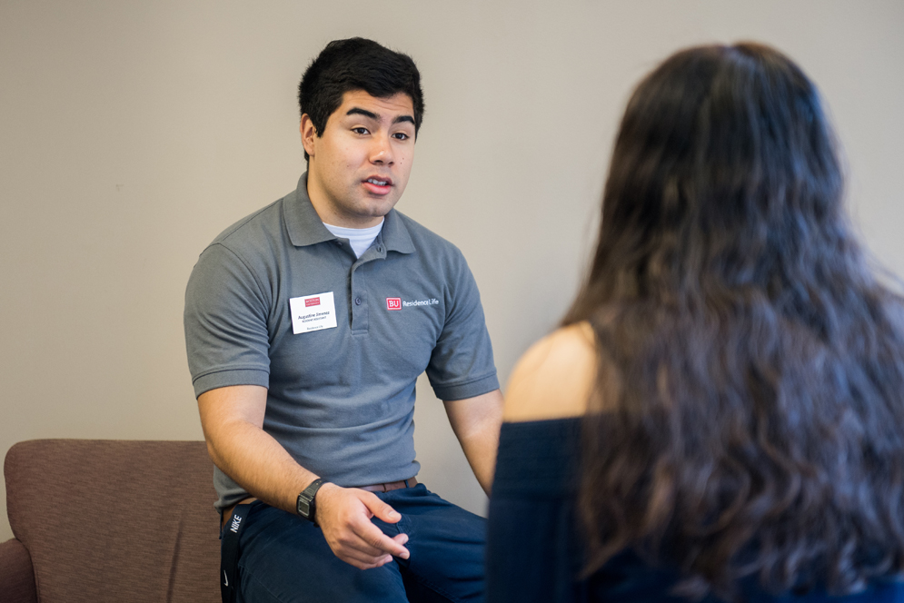 Augustine Jimenez being interviewed while wearing his Residence Life shirt