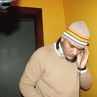 Rahul Desikan holds headphones to his ear while deejaying.