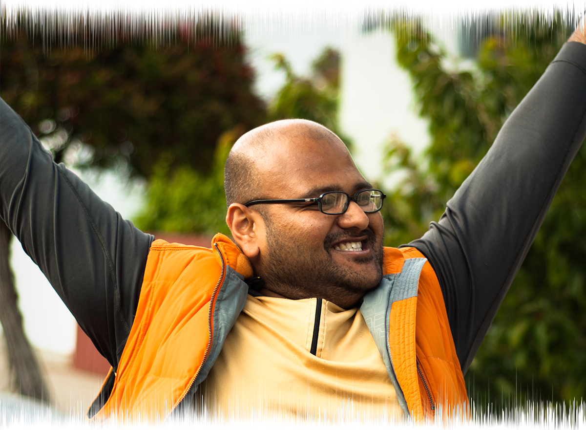 Rahul Desikan smiles and raises his arms up in the air in a 2010 photo before he was diagnosed with ALS.