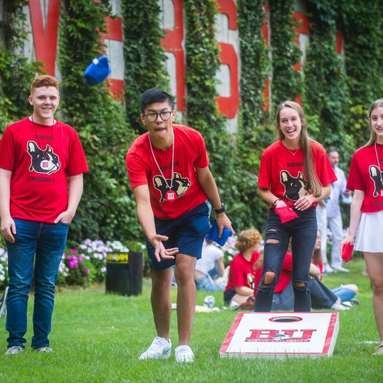 From left: Joe D’Innocenzo (ENG’25), Derek Dong (Questrom’25), Kaylee Sanderson (Questrom’25, Sargent’25), and Maddie Beery (Questrom’25) play cornhole at the Terrier Tailgate