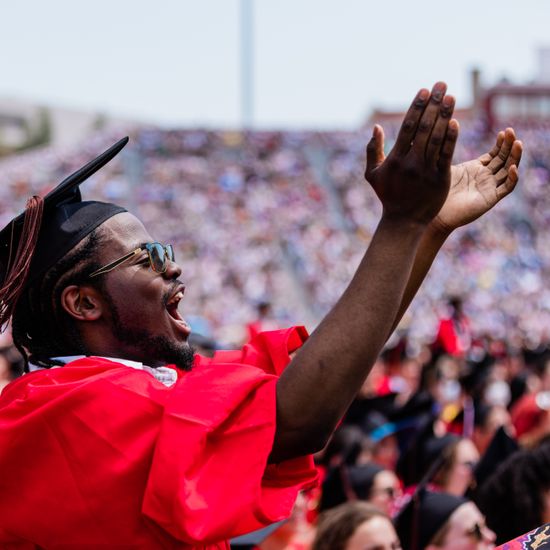A graduate applauds at BU’s Commencement ceremony at Nickerson Field
