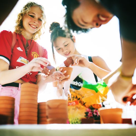 Maggie Lau (Questrom’25, CAS’25) (center) and fellow students pot plants on Marsh Plaza as part of “The Greening of the Dorms”