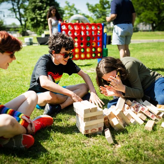 BU Academy students (from left) Coco Mueller, Owen Bergstein, Kaela Harrison, and Andrew Chao play Jenga at a Pride Month barbecue hosted by the Dean of Students office