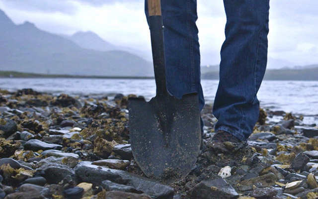 Shovel digging for butter clam shells on a beach in Dutch Harbor.