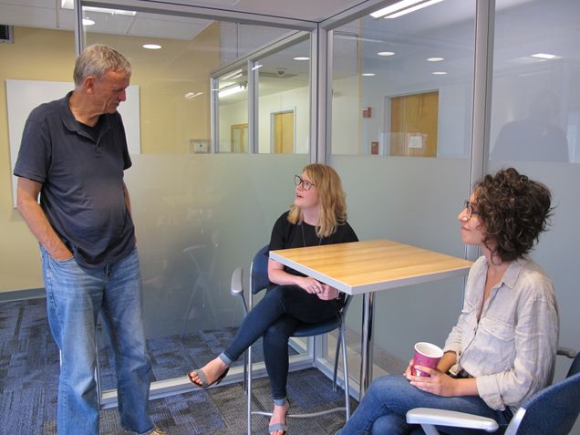 Three people having a conversation in the BU Sociology lounge