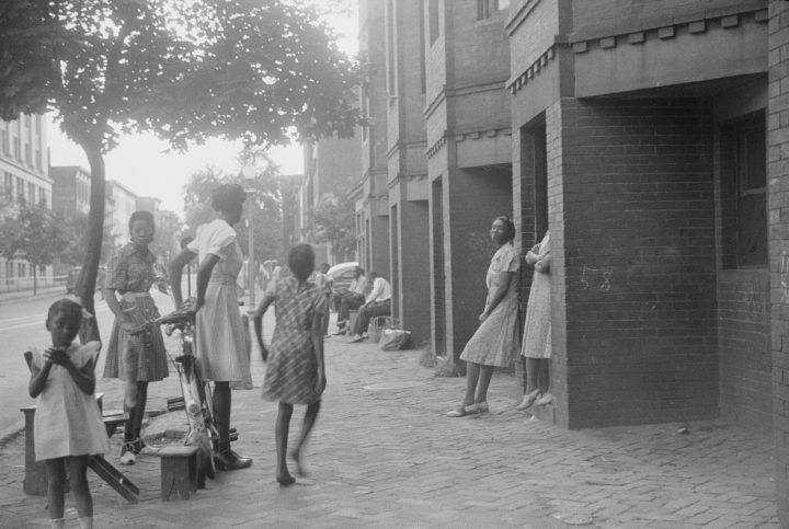 A group of children standing on the sidewalks
