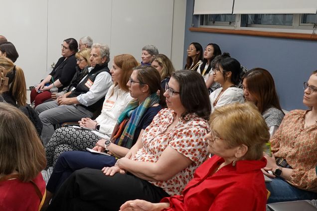Attendees sit and listen attentively