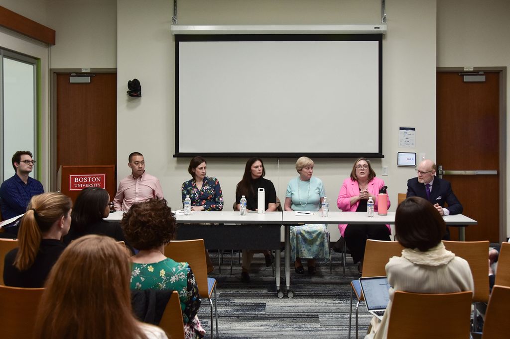 Panelists sit at the front of the room